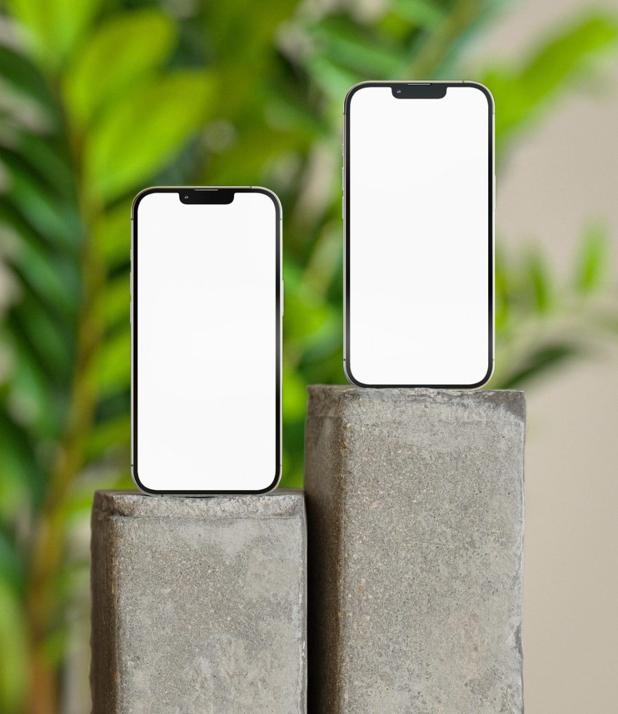 一部竖握的手机屏幕亮着暖橙色界面，武极天下 App 的首页摊开境界速查与人物索引，深棕木桌上一盏台灯投下柔和光晕